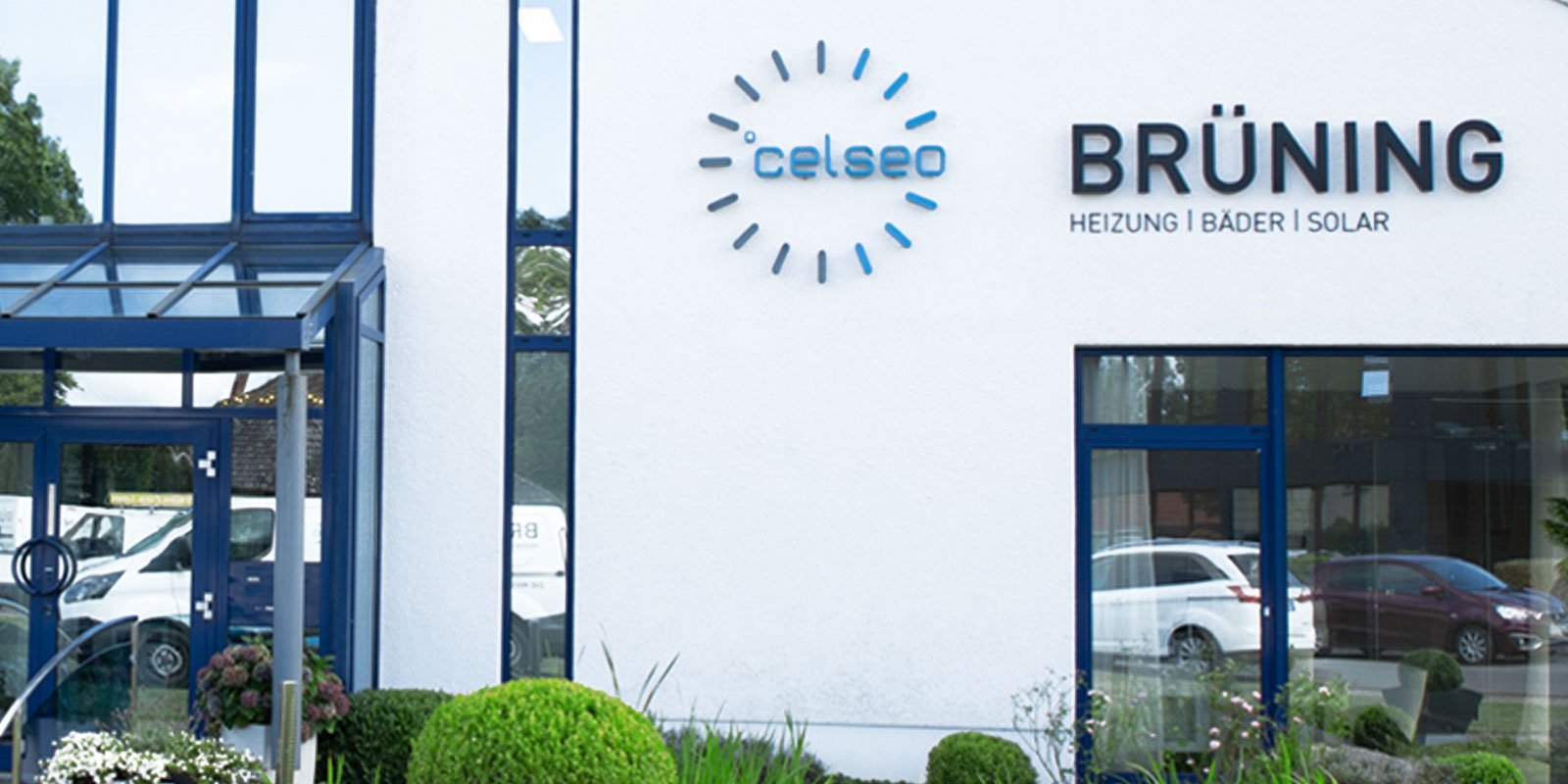 Das moderne Gebäude mit blauen Fenstern und einem einladenden Eingang zeigt die Firma Brüning, spezialisiert auf Heizungen und Solar.