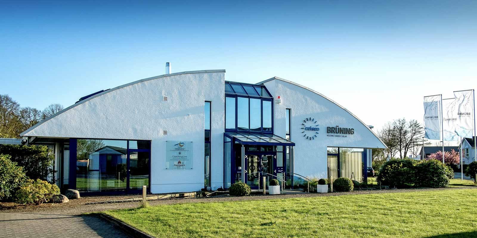 Die Fassade des Unternehmens zeigt eine einladende Eingangstür und ein großes Fenster, das den Innenraum beleuchtet.