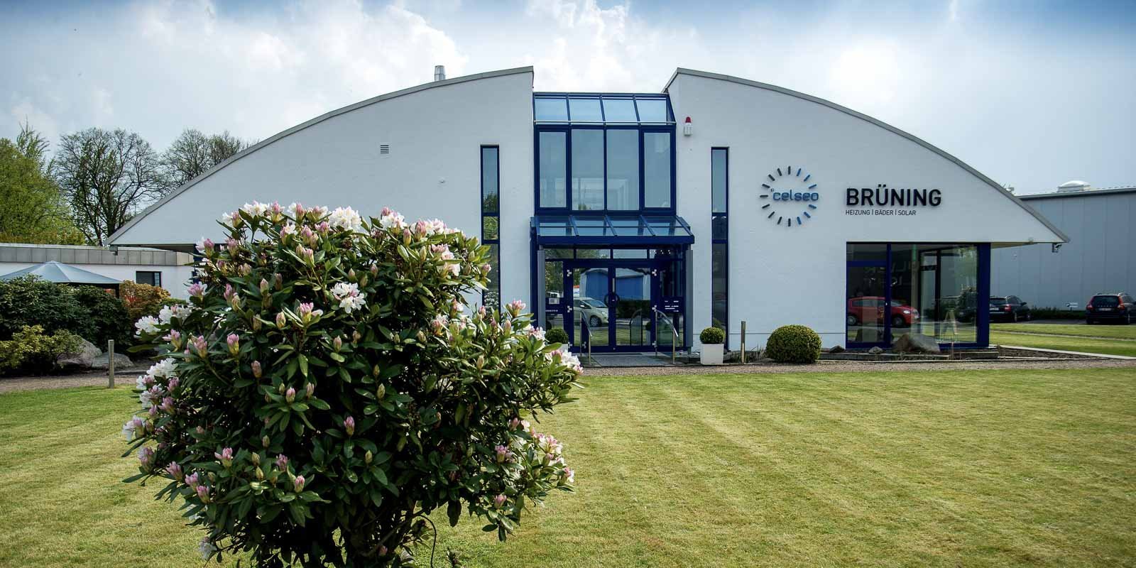 Die Fassade des Unternehmens BRÜNING zeigt eine einladende Eingangstür und ein stilvolles Logo über dem Eingang.