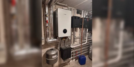 Die Heizungsinstallation zeigt eine Kombination aus verschiedenen Rohren und Geräten, die für die Wärmeversorgung genutzt werden.