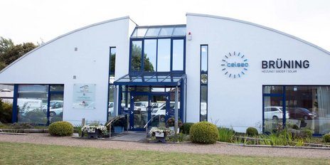 Das moderne Gebäude mit einer gläsernen Eingangstür und dem Schriftzug 'Brüning' strahlt einladende Atmosphäre aus.